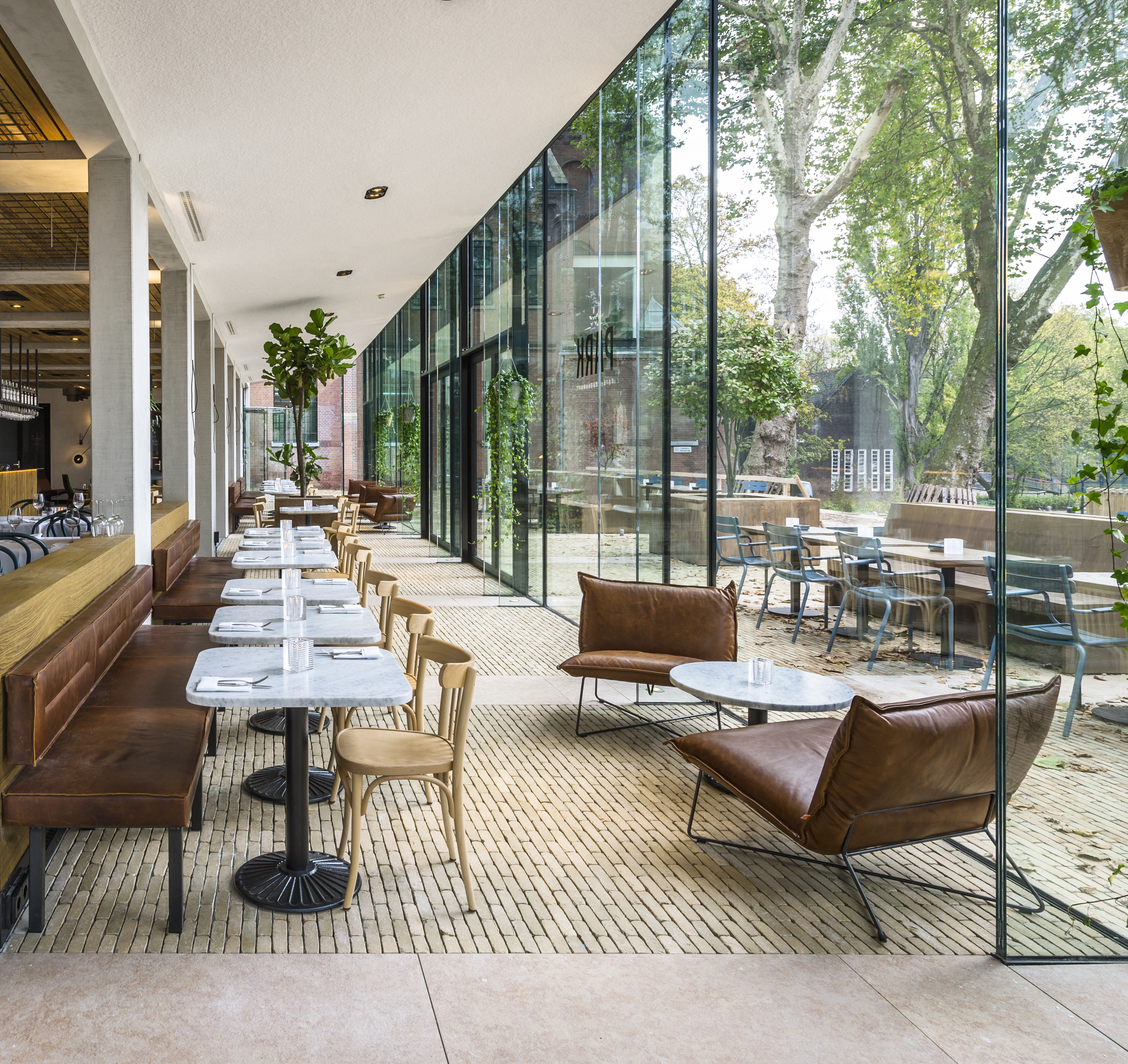 Le pavé Ancienne Belgique jaune bronze assure la transition entre les pavillons transparents et la terrasse